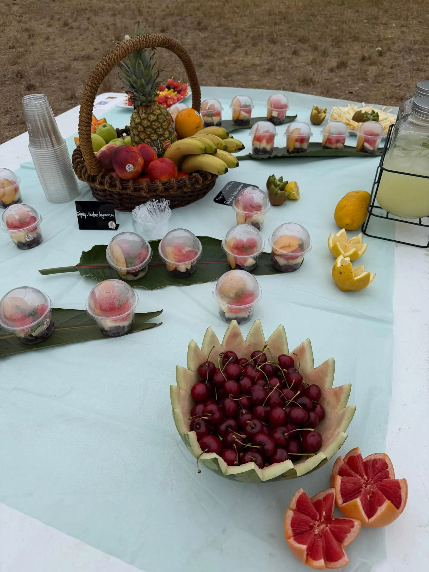 Taça de melancia com cerejas numa mesa de catering July